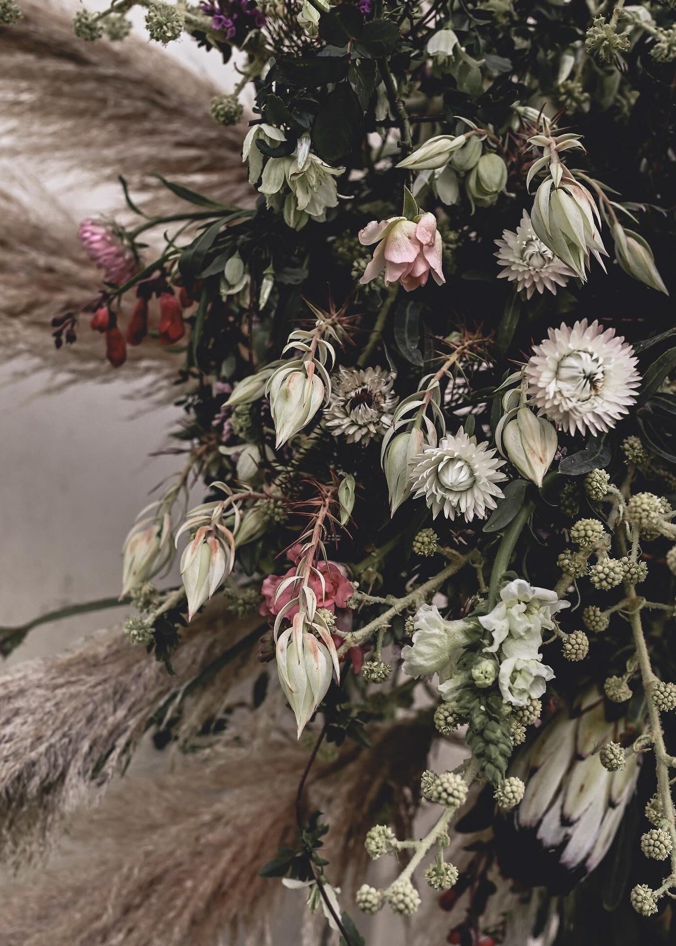 Close-up of a floral arrangement with various flowers and greenery.