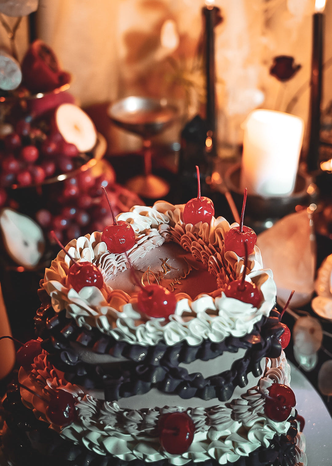 Decorative cake with cherries on a table setting.