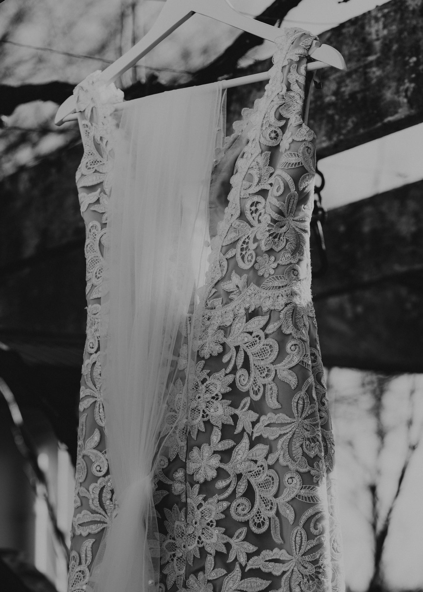 Lace wedding dress hanging on a stand with a blurred background